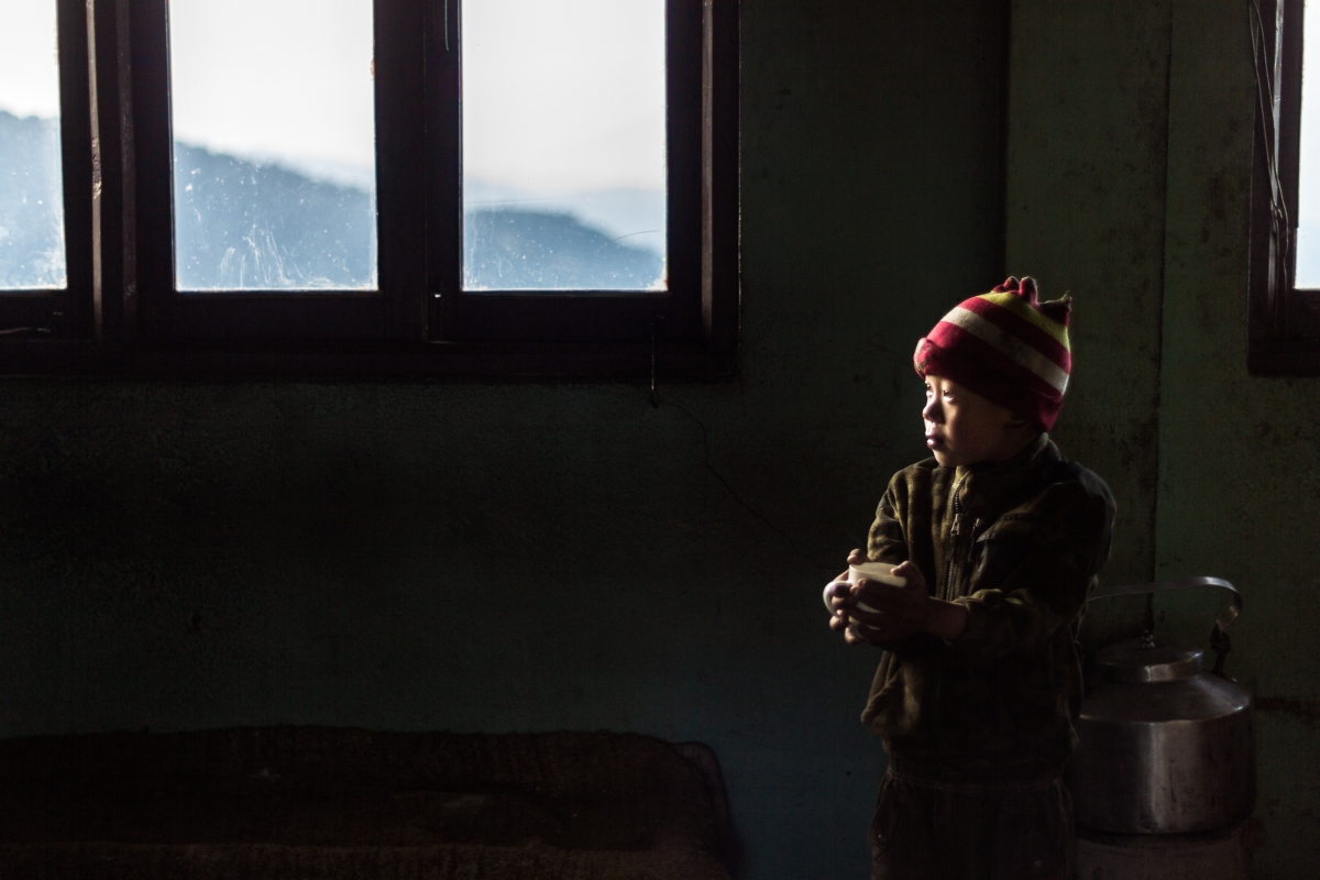 Boy with a red hat in a shed in Nepal