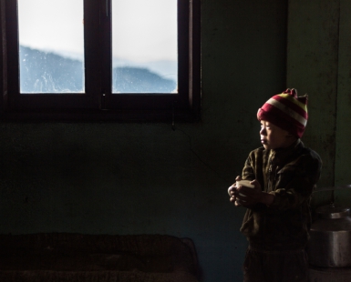 Boy with a red hat in a shed in Nepal